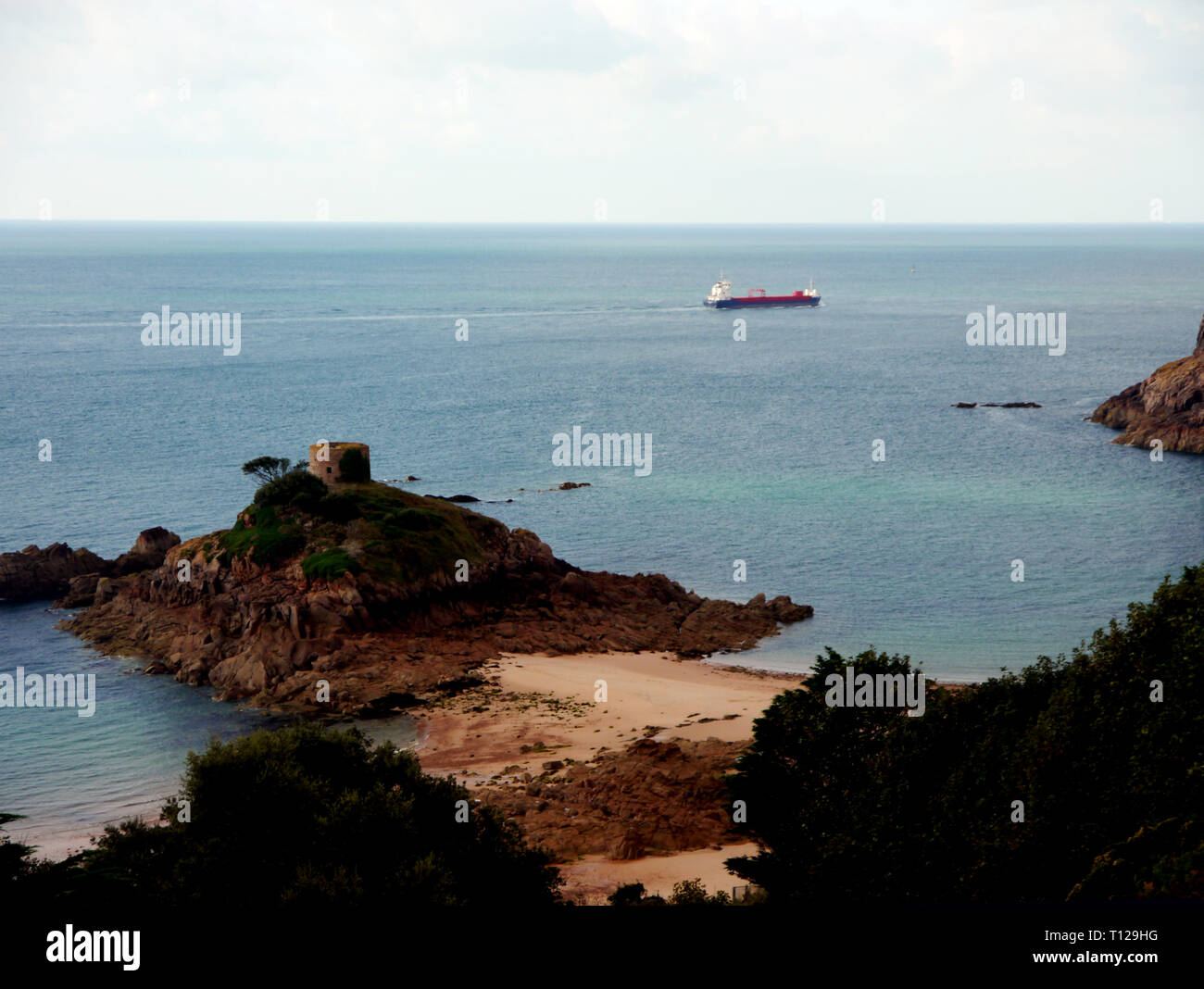 Cargo Ship Passing Portelet Tower on a Rocky Tidal Island in Portlet