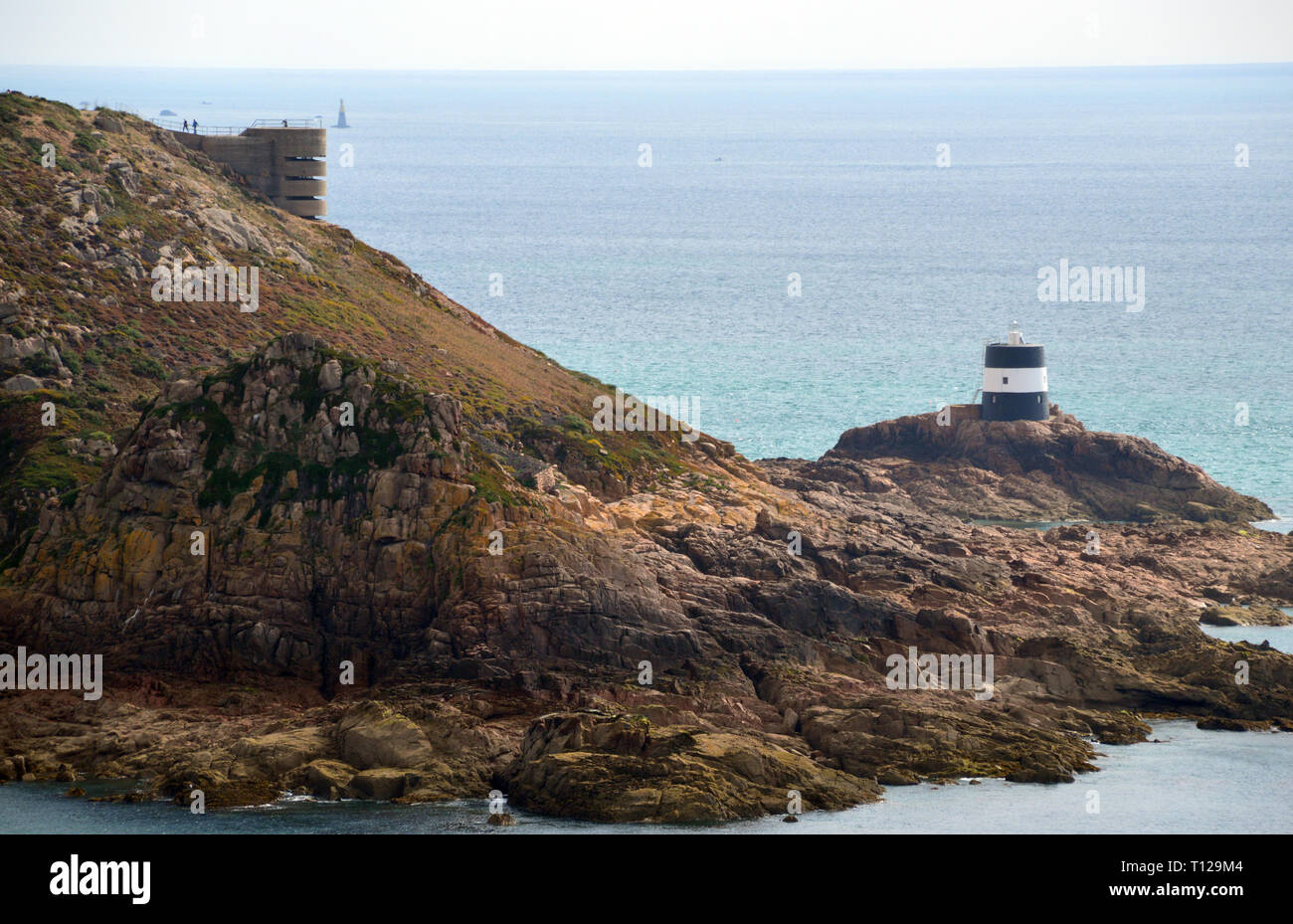 WW2 Bunker/Lookout & the Black and White La Tour de Vinde (Noirmont Tower) Lighthouse in St Aubin's Bay on the Island of Jersey, Channel Isles, UK. Stock Photo