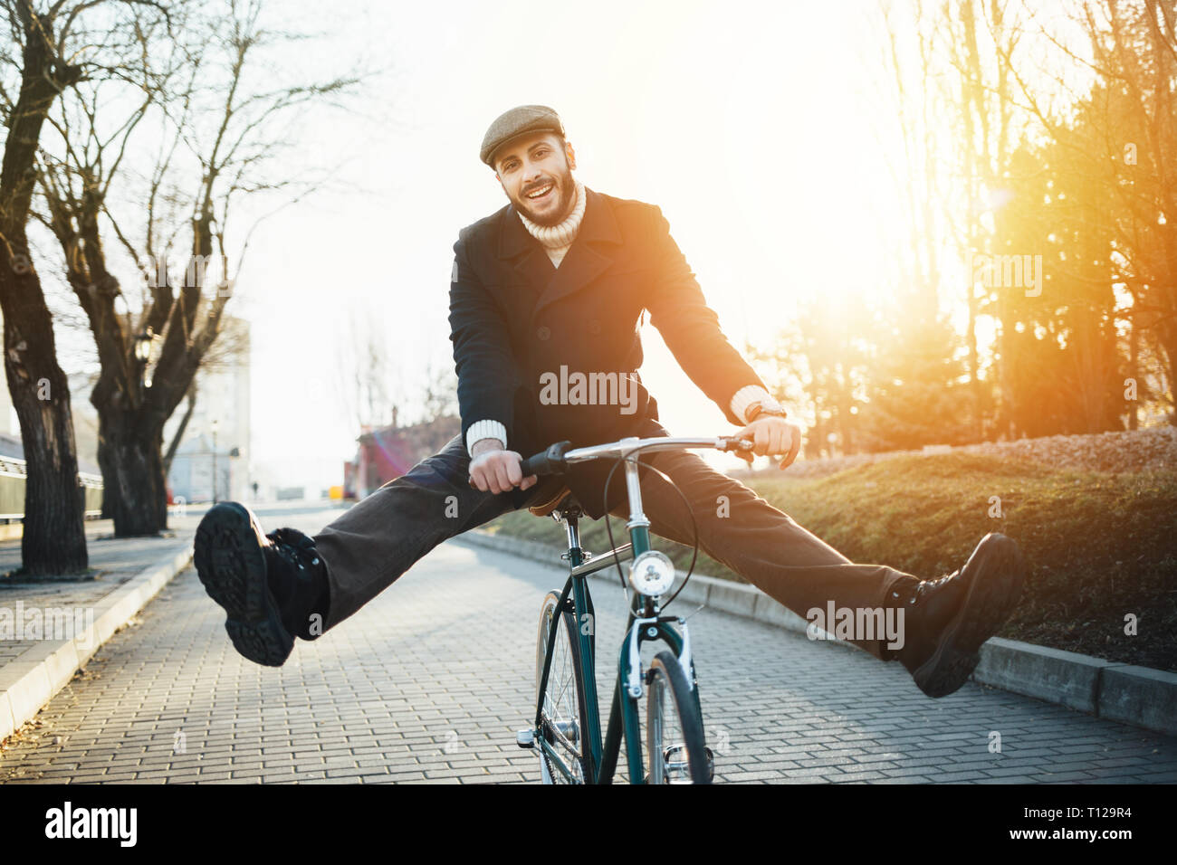 Smiling hipster man with bicycle having fun Stock Photo