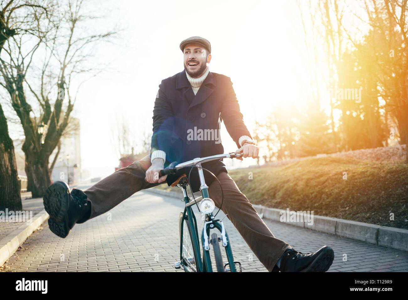 Smiling hipster man with bicycle having fun Stock Photo