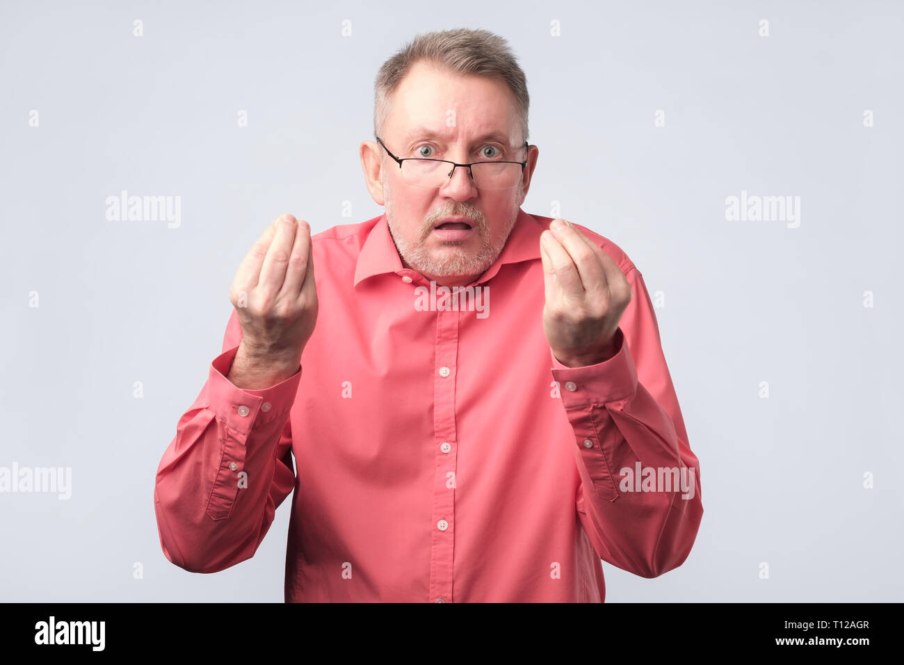 Senior man looking angry showing italian gesture. Stock Photo