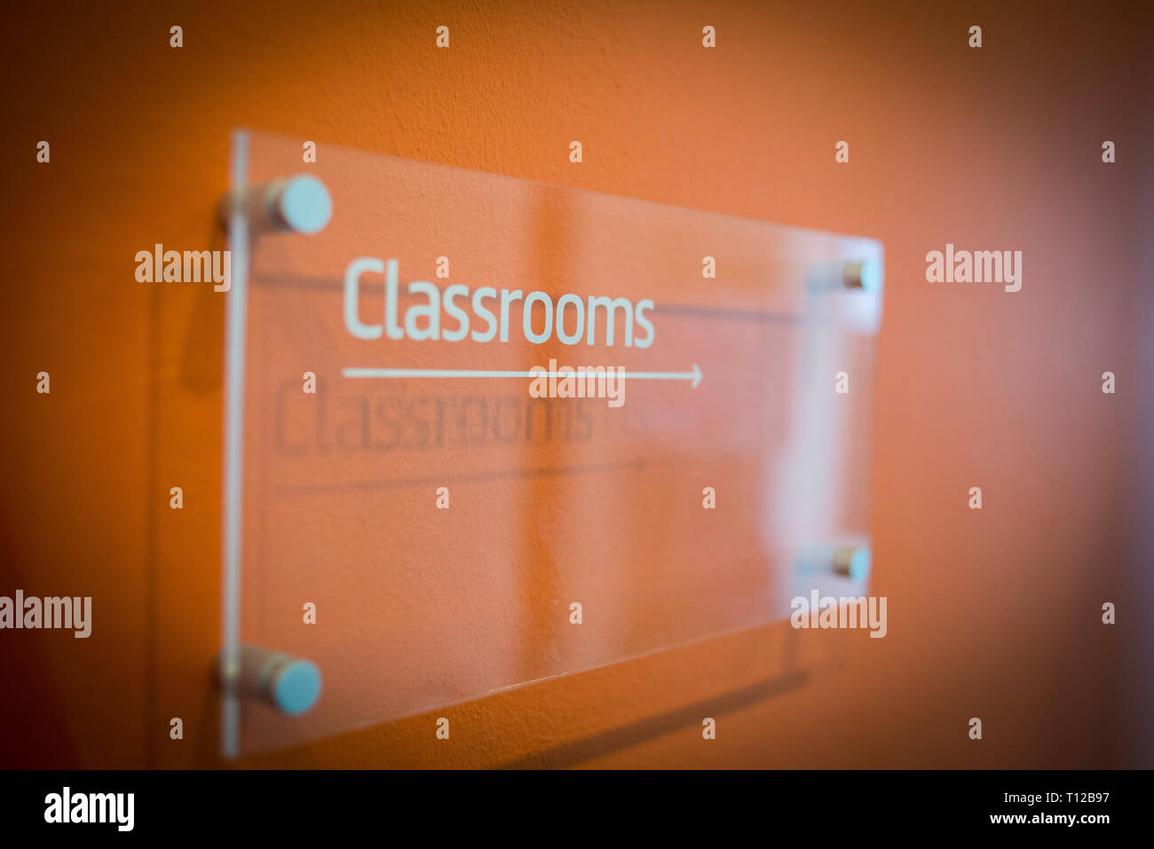 A sign on the wall points to the classrooms of a college Stock Photo