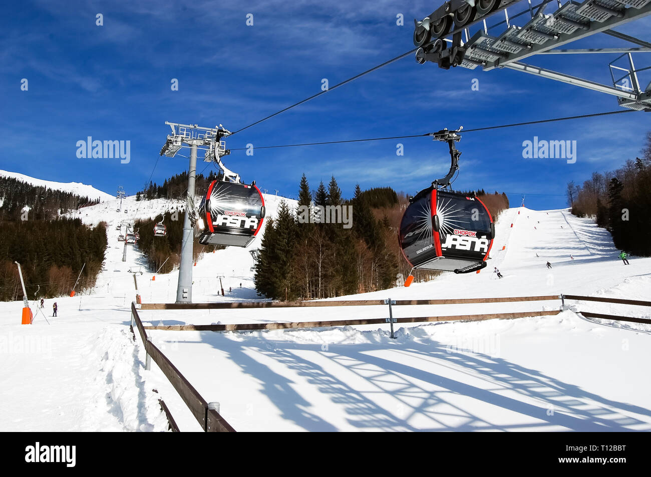 Jasna, Slovakia - January 22, 2019: Cabins of the cableway at the station and view of the ski slopes from the south side of Chopok mountain on a sunny Stock Photo