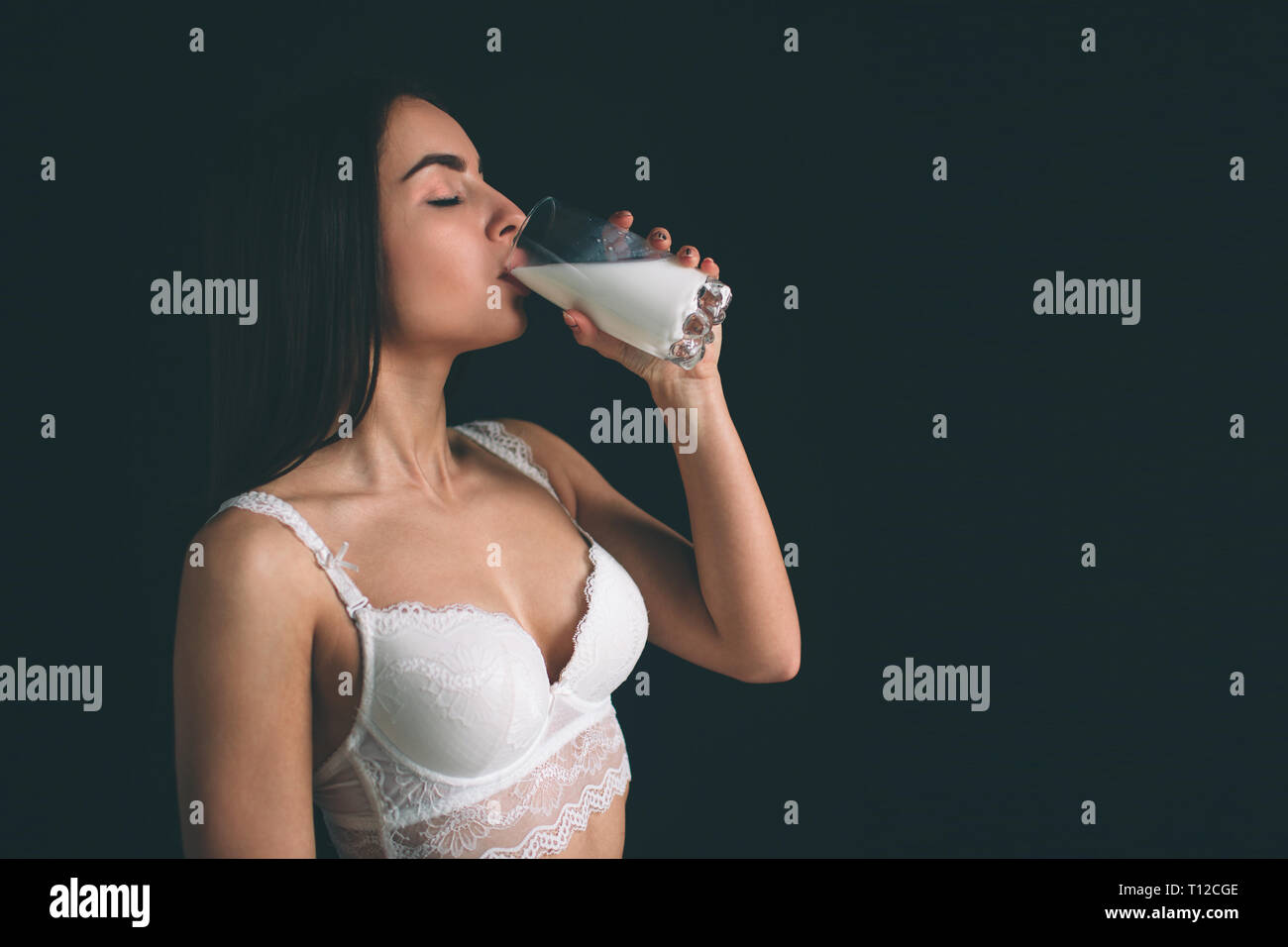 Female model drink milk on white background. Young woman with long black hair stands isolated on black background. The girl has a sports figure, she i Stock Photo - Alamy Female model drink milk on white background. Young woman with long black hair stands isolated on black background. The girl has a sports figure, she i Stock Photo - Alamy