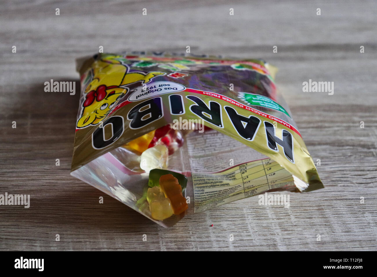 An open pack of Haribo sweets on a wooden table. Stock Photo