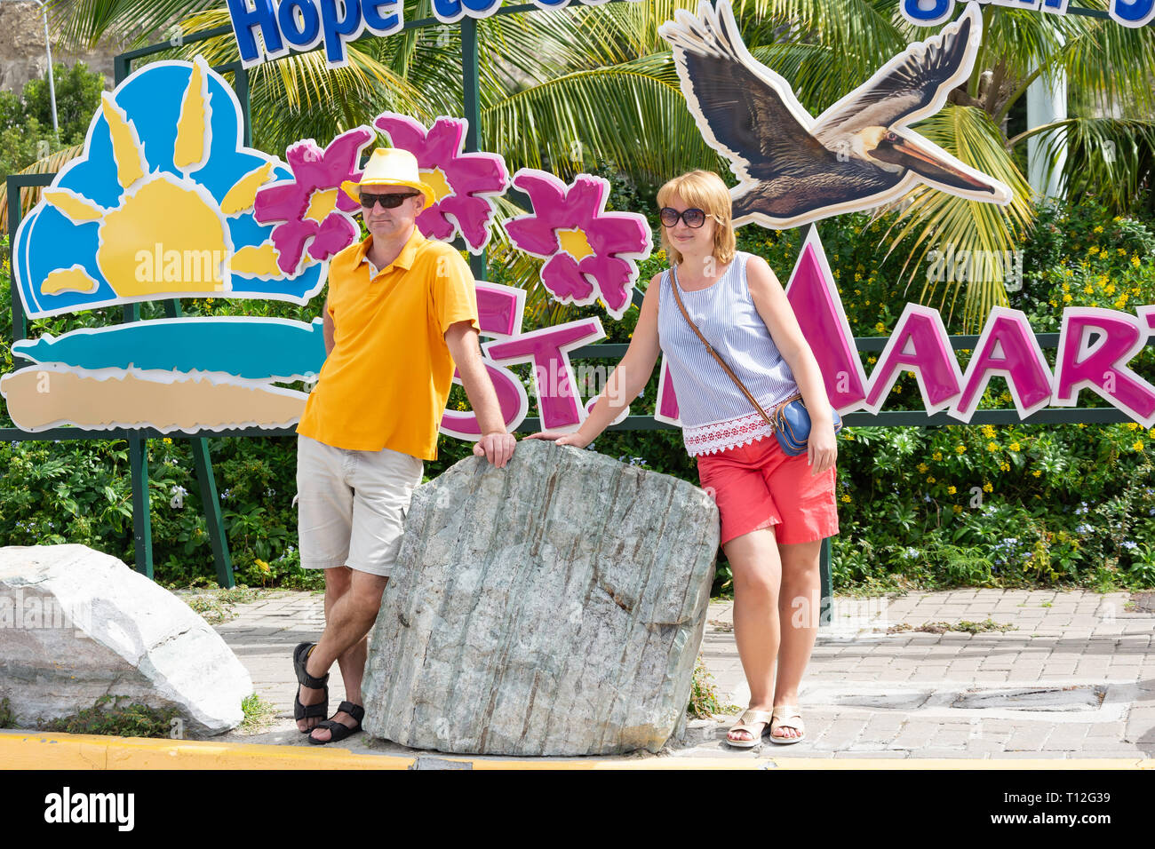 Couple posing in front of St Maarten farewell sign at Cruise Terminal, Philipsburg, St Maarten, Saint Martin, Lesser Antilles, Caribbean Stock Photo