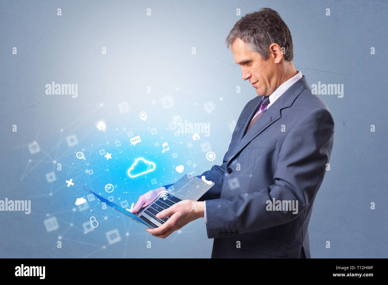 Man holding laptop projecting notifications, symbols and information based on cloud technology system  Stock Photo