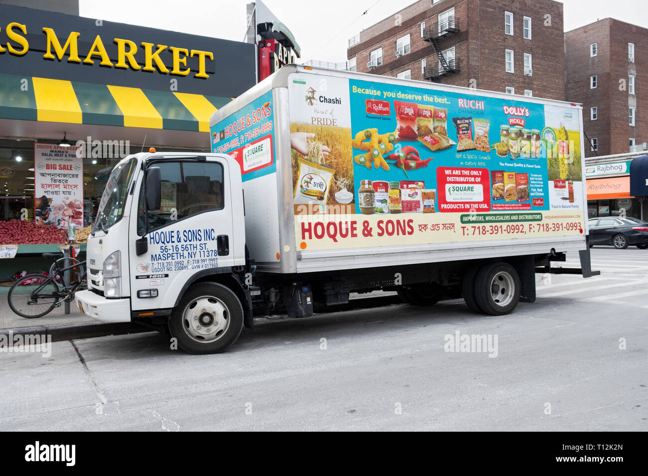 A Hoque & Sons delivery truck with English and Bengali writing making a delivery to a the Apna Bazar market in Jackson Heights, Queens, New York City Stock Photo