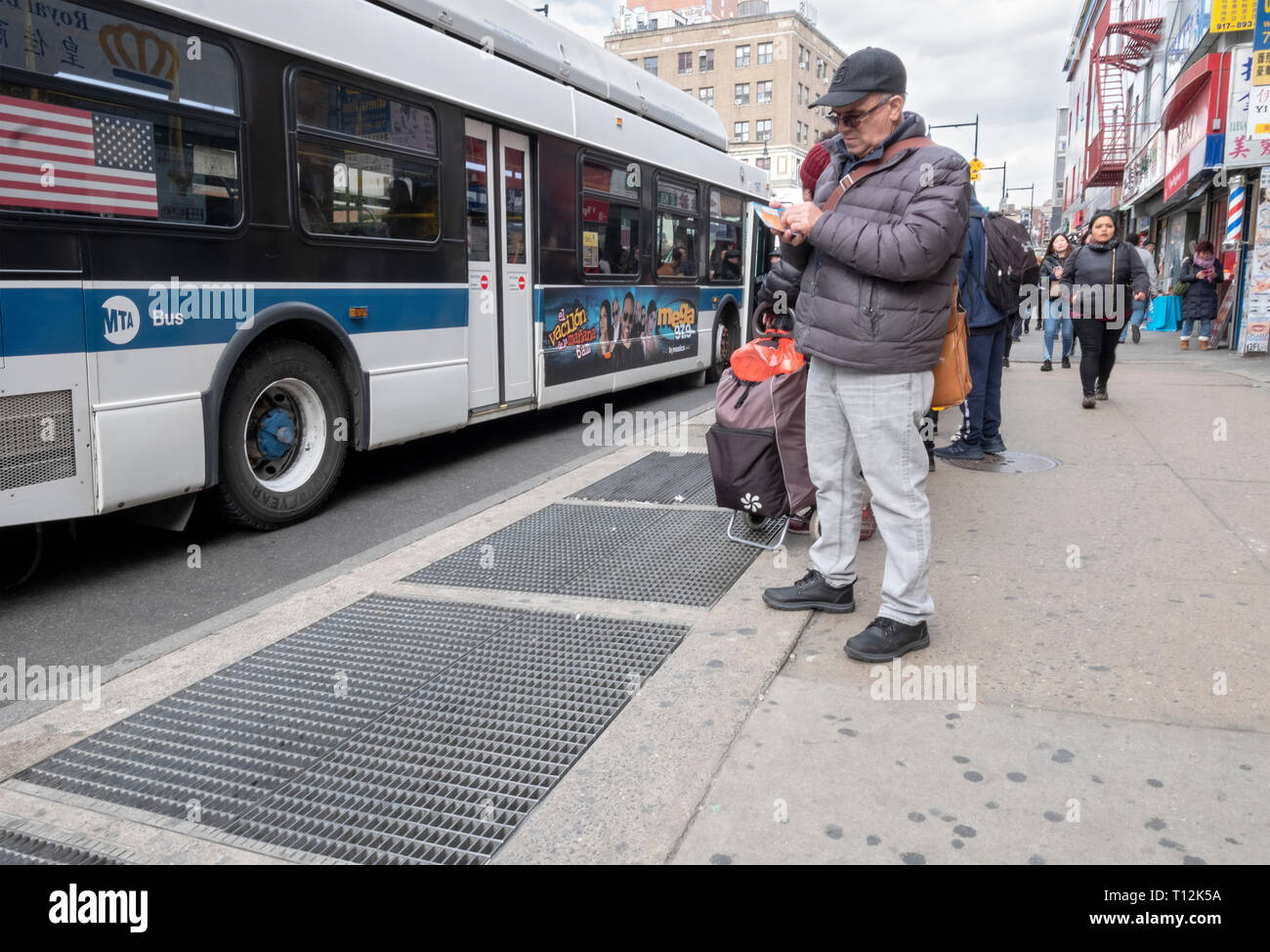 On line waiting for his bus, a middle aged man checks his scratchoff