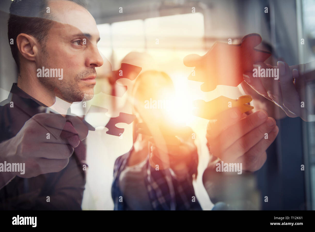 Business people join puzzle pieces. Concept of teamwork and partnership. double exposure Stock Photo