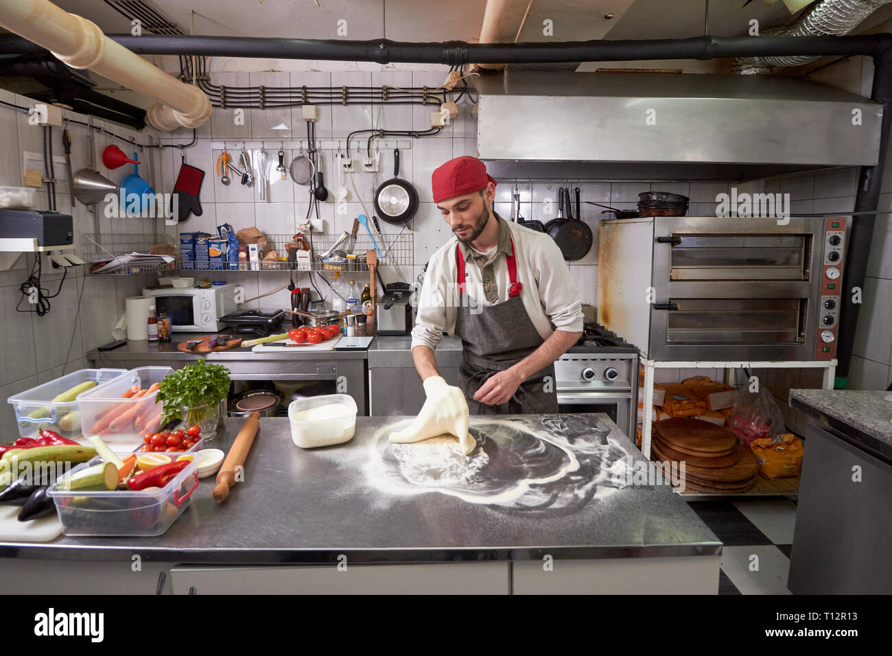 One Young Chef 20 29 Years Old Making A Pizza Dough In A Commercial Kitchen Stock Photo Alamy