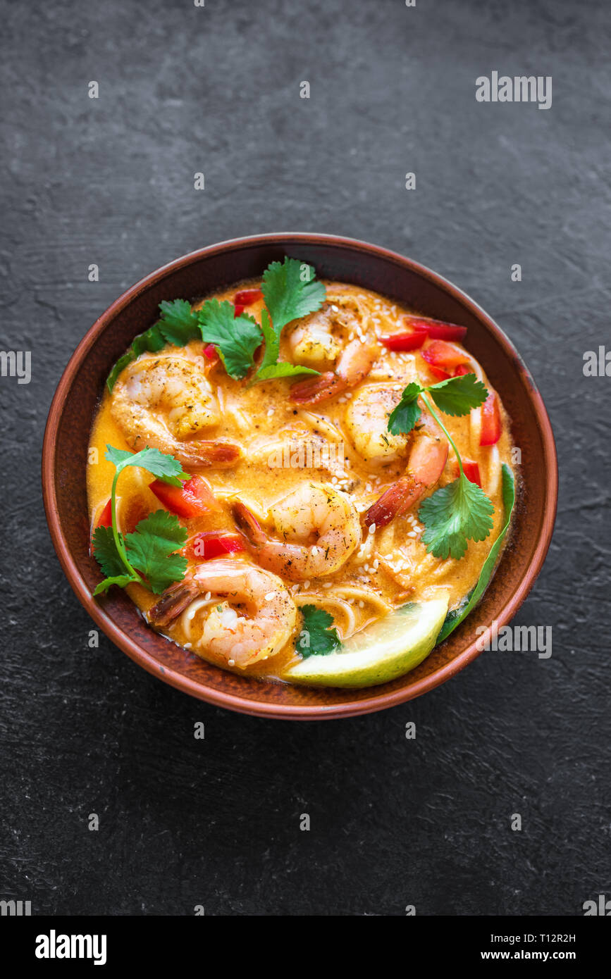 Laksa Shrimp Soup. Prawn noodle laksa soup on black background, top view, copy space. Asian Malaysian food. Stock Photo