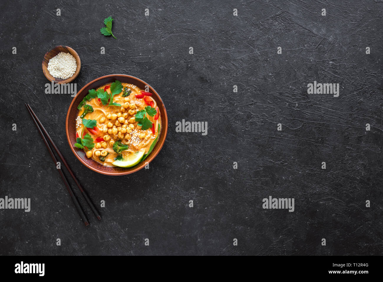 Laksa Soup. Vegetable noodle laksa soup on black background, top view, copy space. Asian Malaysian vegan vegetarian food. Stock Photo