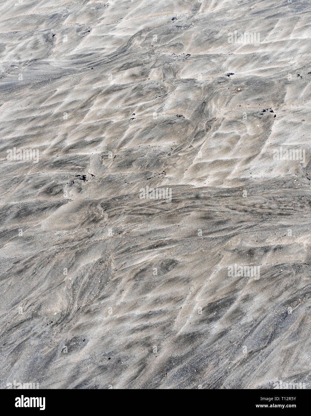 Sedimentary fluid sand flows, Mars-like water flow patterns on a tidal beach. Metaphor 'go with the flow', movement, landscape just like Mars. Stock Photo