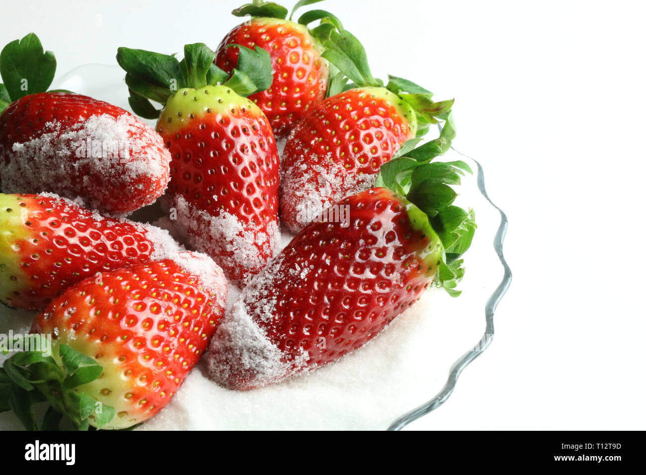 Fresh strawberries with sugar on white background Stock Photo - Alamy