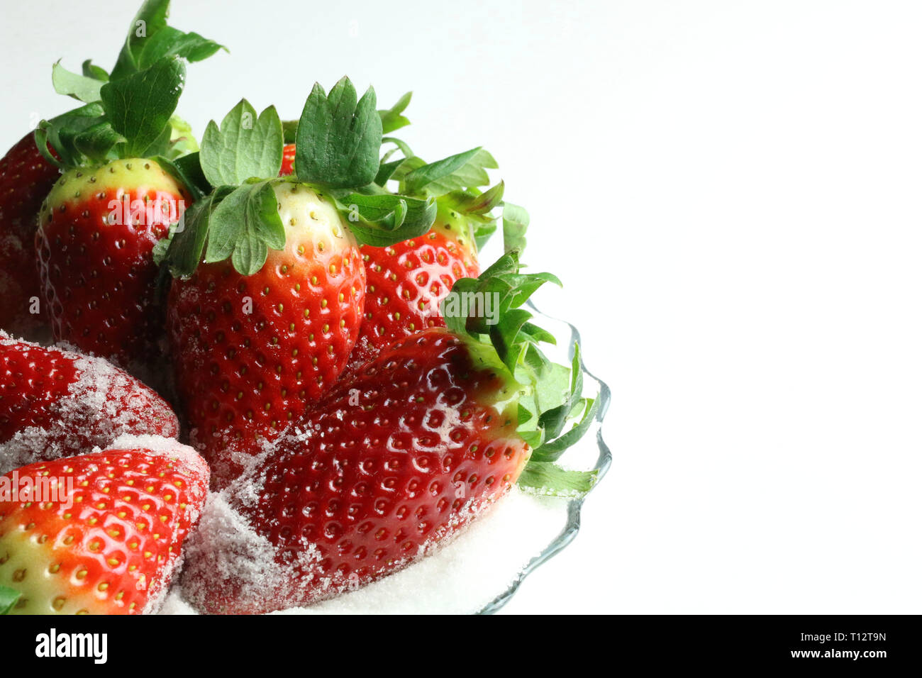 Fresh strawberries with sugar on white background Stock Photo - Alamy