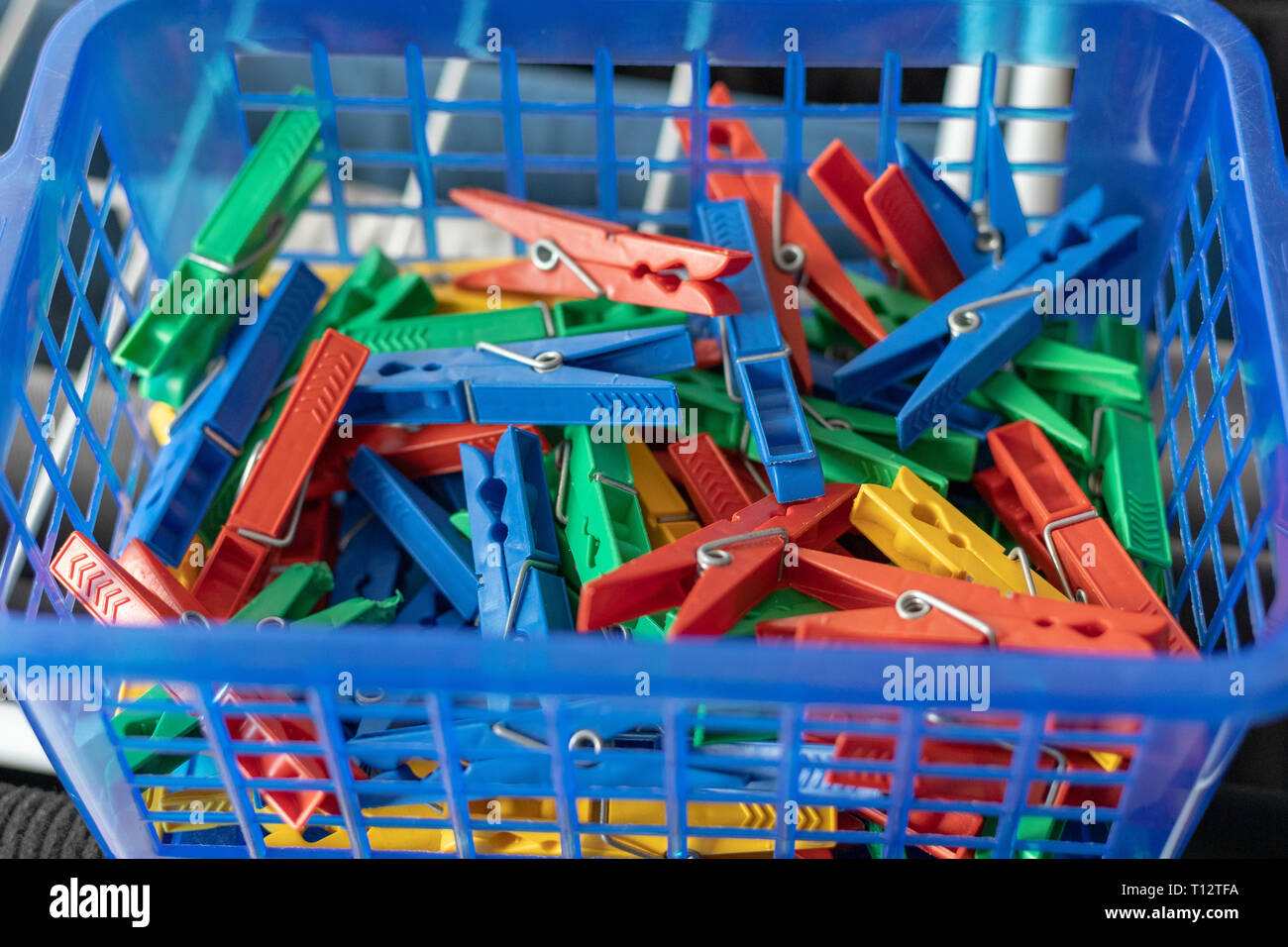 Colorful clothespins in a blue basket Stock Photo Alamy