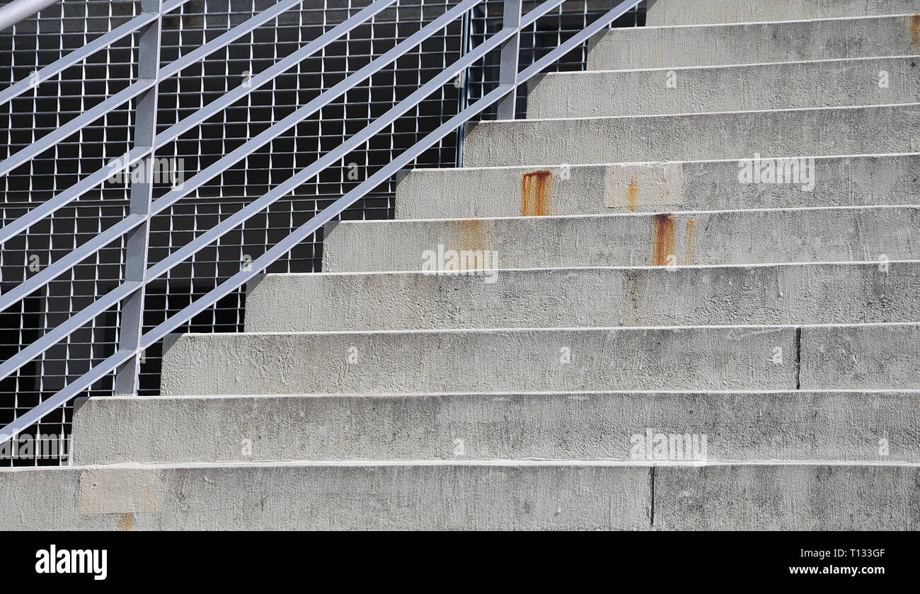 steel railing at an outdoor stairway with cement steps seen from below Stock Photo