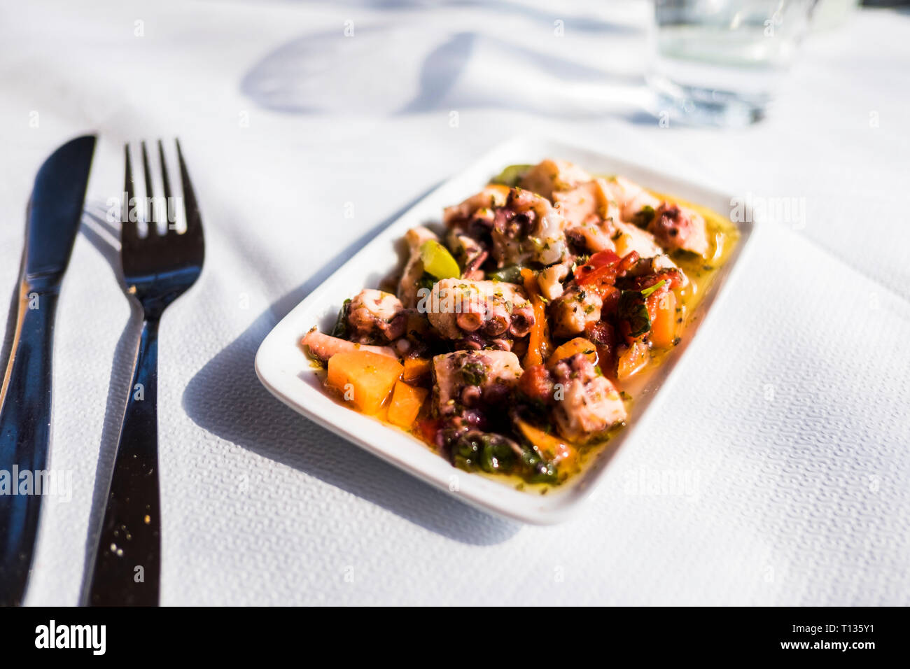 Mmm, fresh grilled octopus salad as an appetizer at a seaside outdoor cafe for lunch in Thessaloniki, Greece. Stock Photo