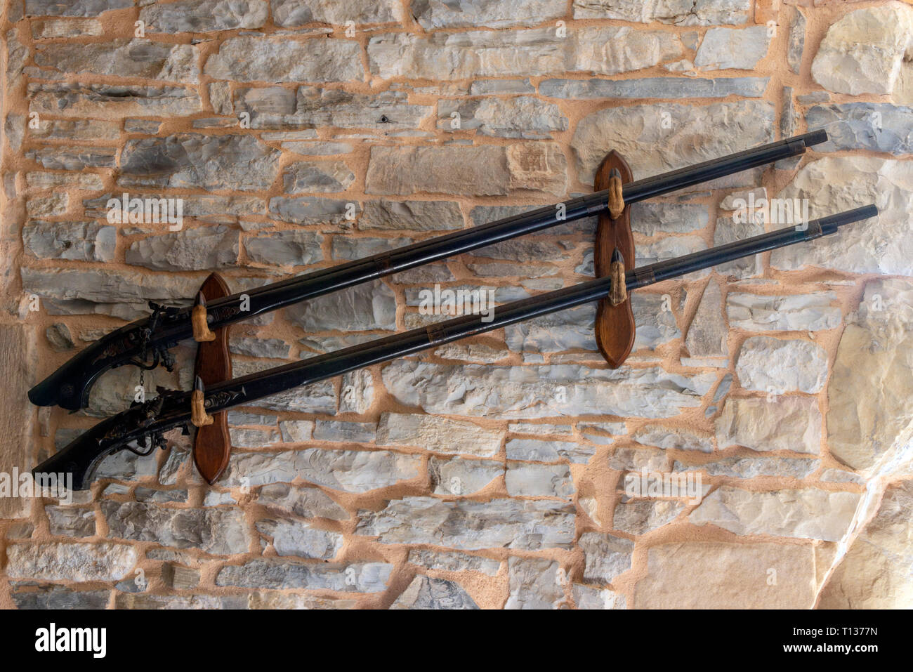 https www alamy com two long antique indonesian muskets mounted in a gun rack on a wall image241631369 html