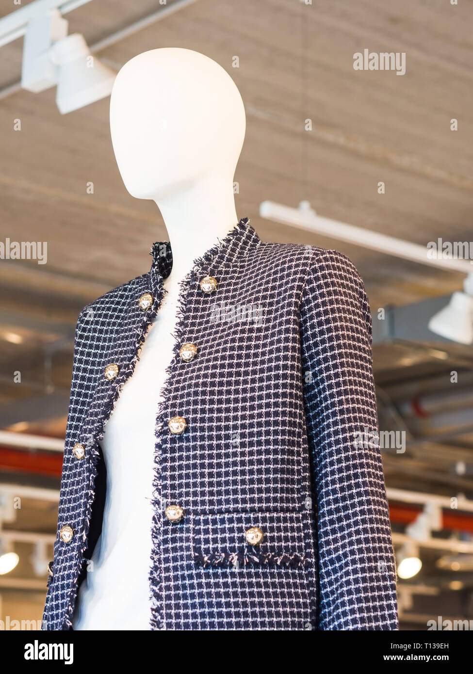 White mannequin wearing jacket in a fast fashion store Stock Photo