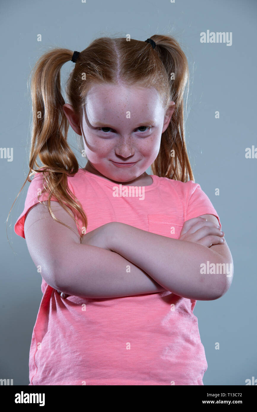 a red haired girl with her arms folded. Stock Photo