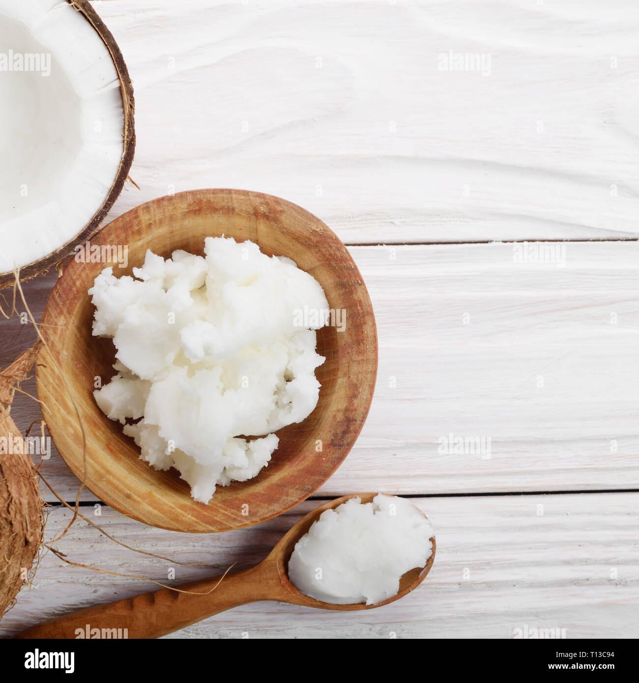 Flat lay background of coconut shell hard oil in wooden bowl on white wooden table Stock Photo