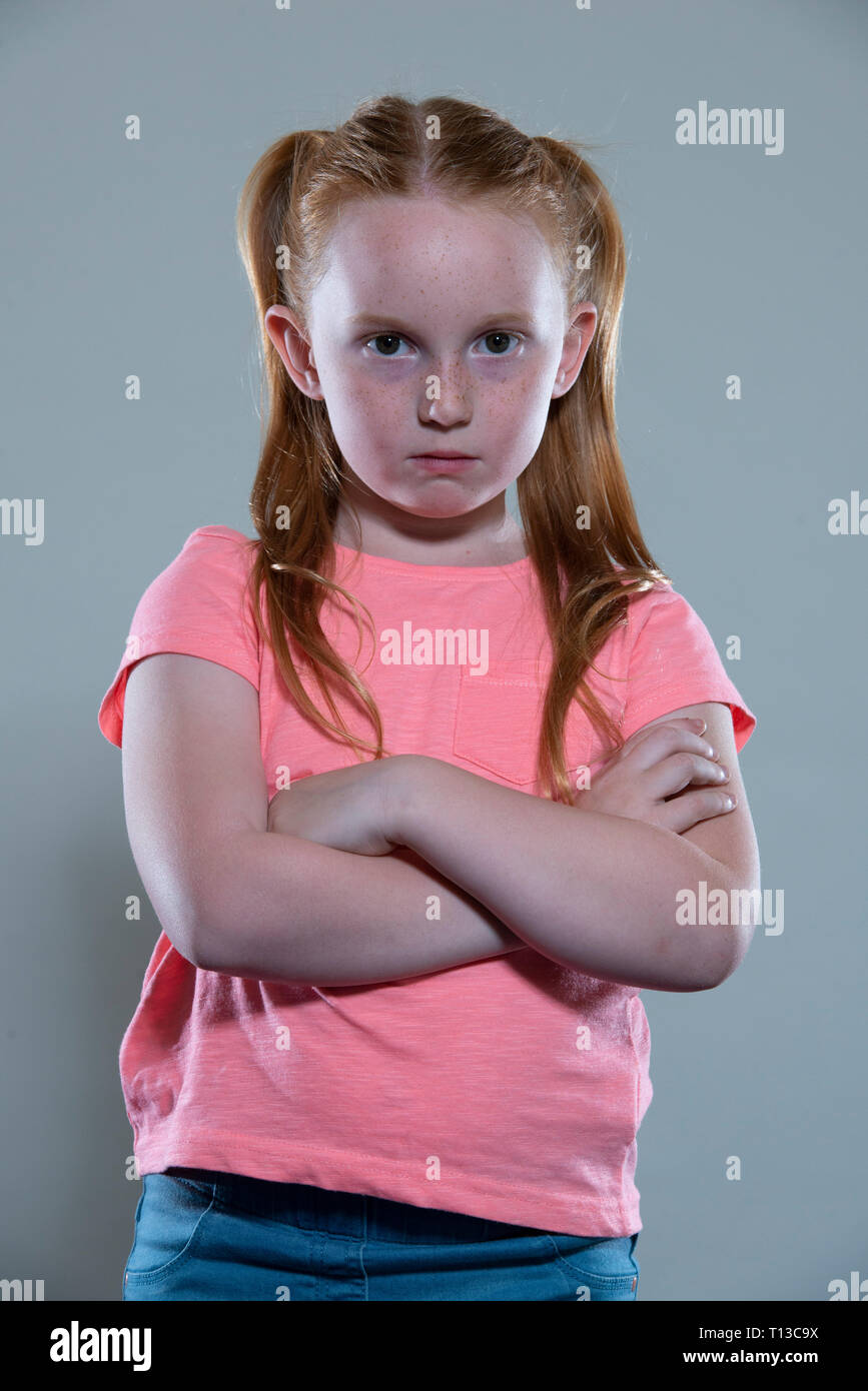 a red haired girl with her arms folded. Stock Photo