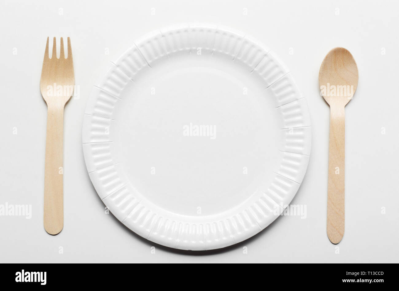 Top view at wooden single use kitchenware and paper plate on white ...