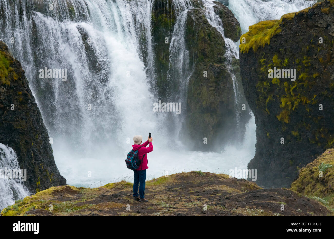 Tourist photographing Sigoldu Waterfall, Iceland Stock Photo