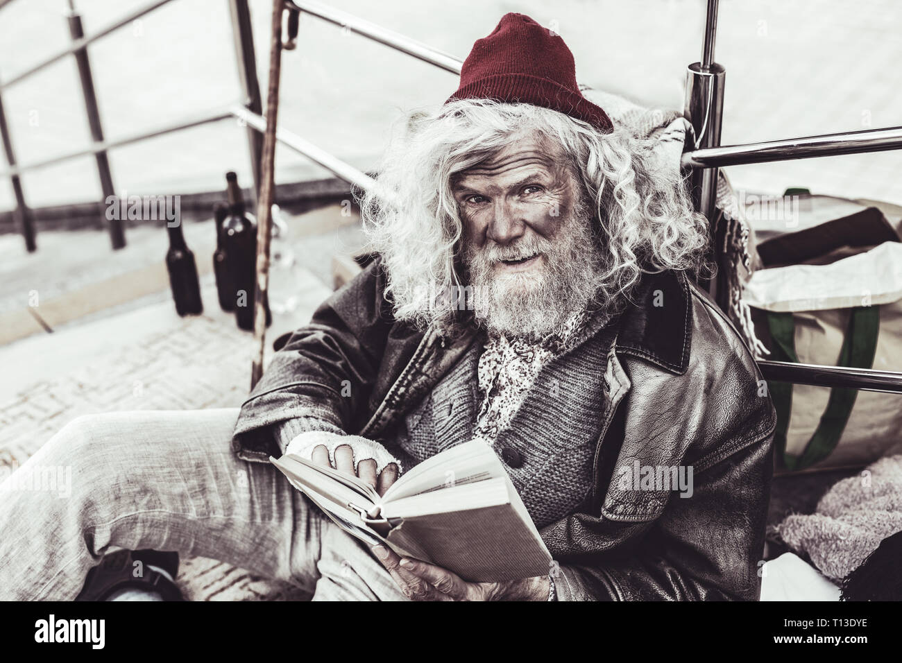 Mendicant retelling the plot of the book to the passerby while reading. Stock Photo