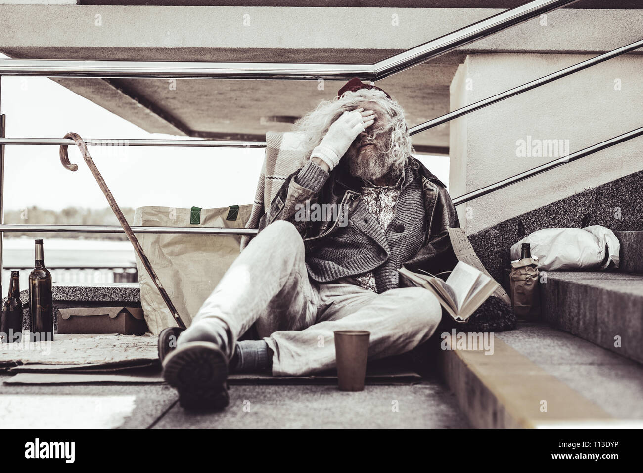 Homeless Caucasian man feeling sick of this kind of life. Stock Photo