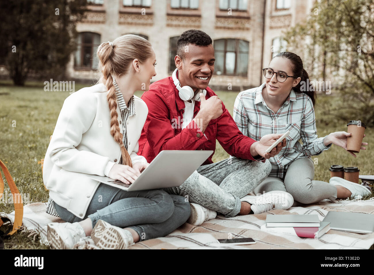 Positive delighted young people talking about studying Stock Photo