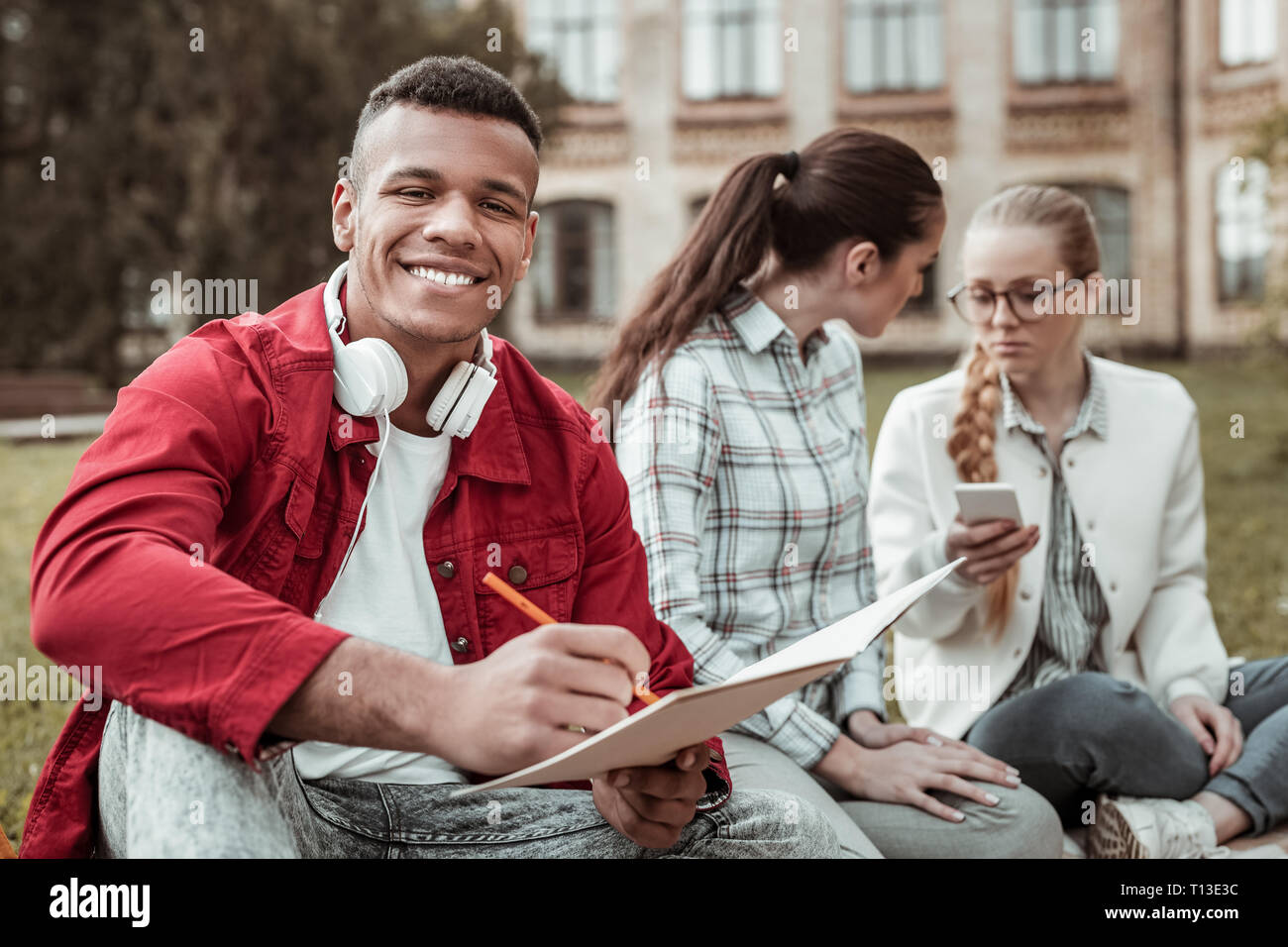 Attractive dark-skinned man feeling happiness while studying Stock Photo