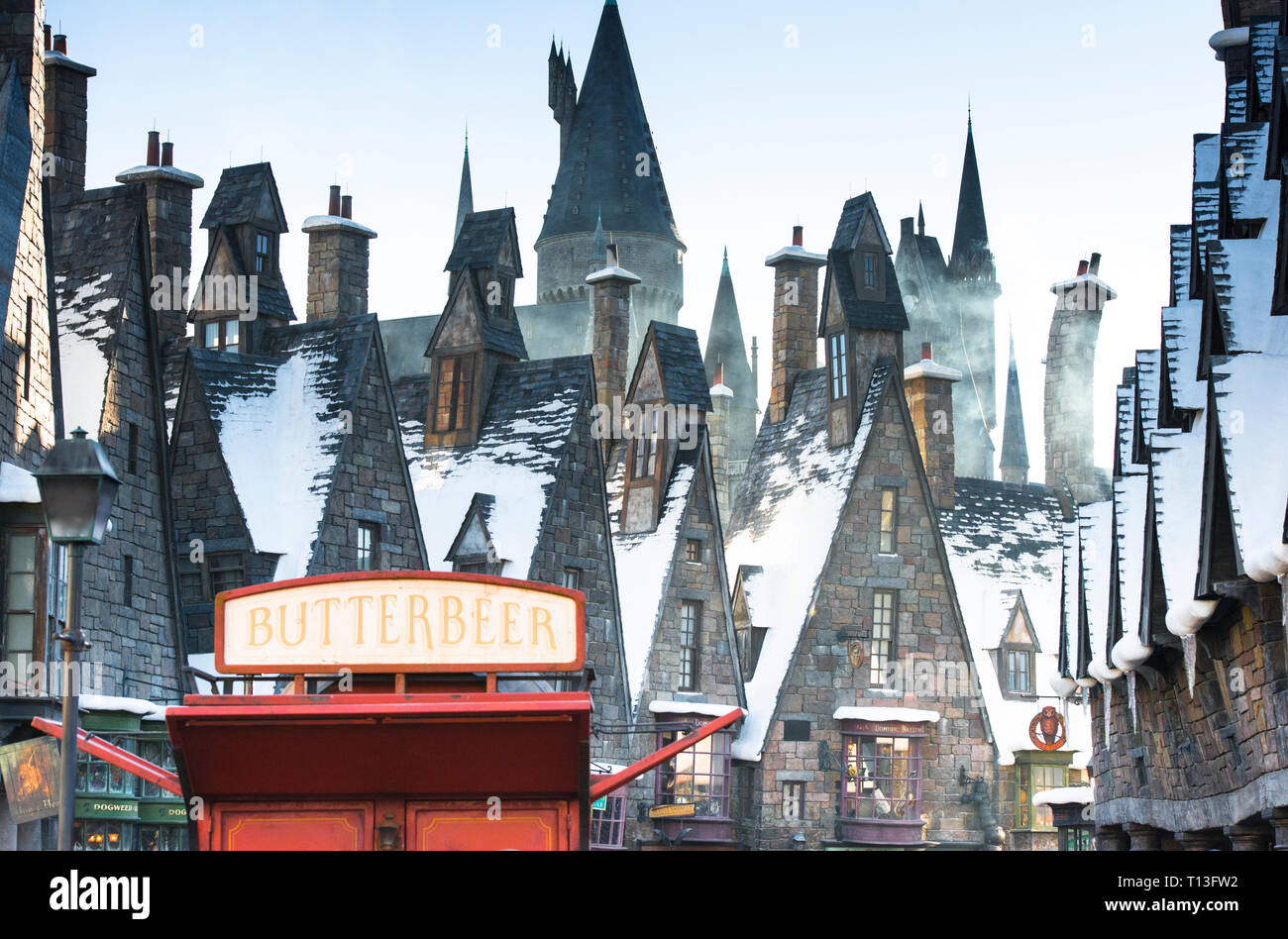 Landscape view of Hogsmeade, The Wizarding World of Harry Potter with a bright red Butterbeer sales stand in the foreground. No people in scene. Stock Photo