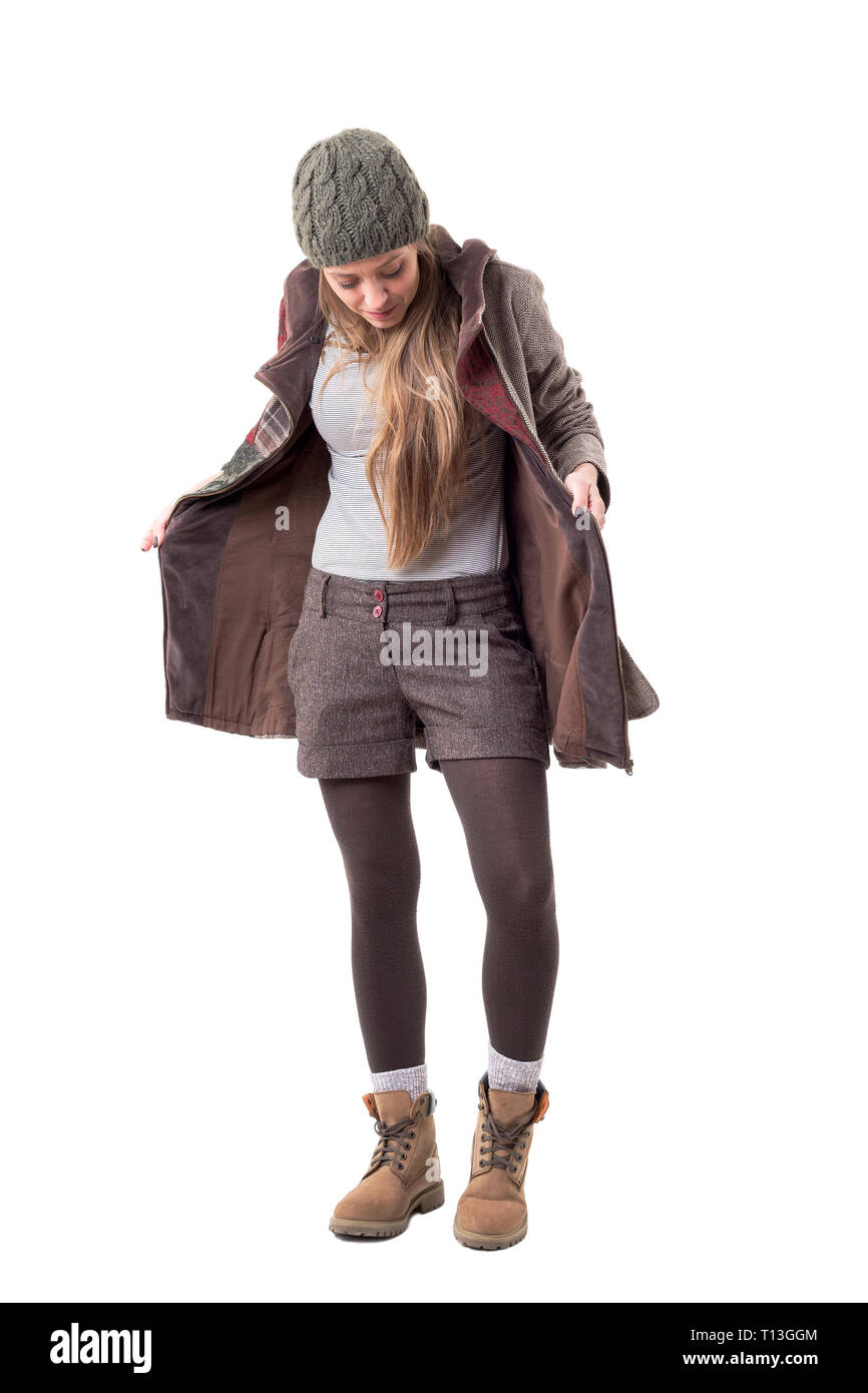 Stylish young woman in winter coat looking for and searching something lost in pockets. Full