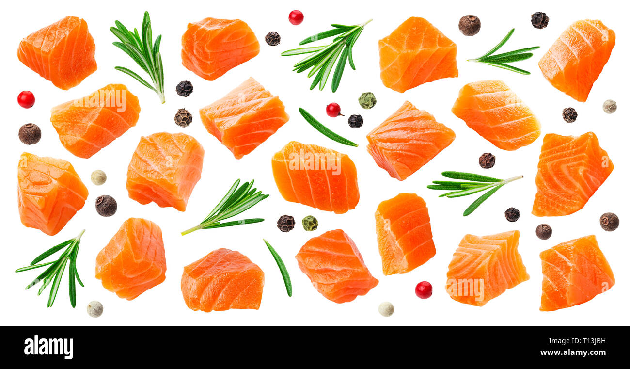 Salmon slices isolated on white background with clipping path, cubes of red fish with rosemary and peppercorns, ingredient for sushi or salad Stock Photo