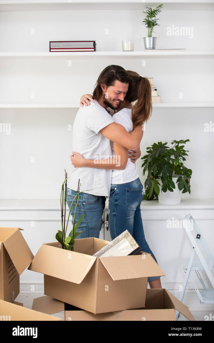 Couple with cardboard boxes hugging in new home Stock Photo - Alamy