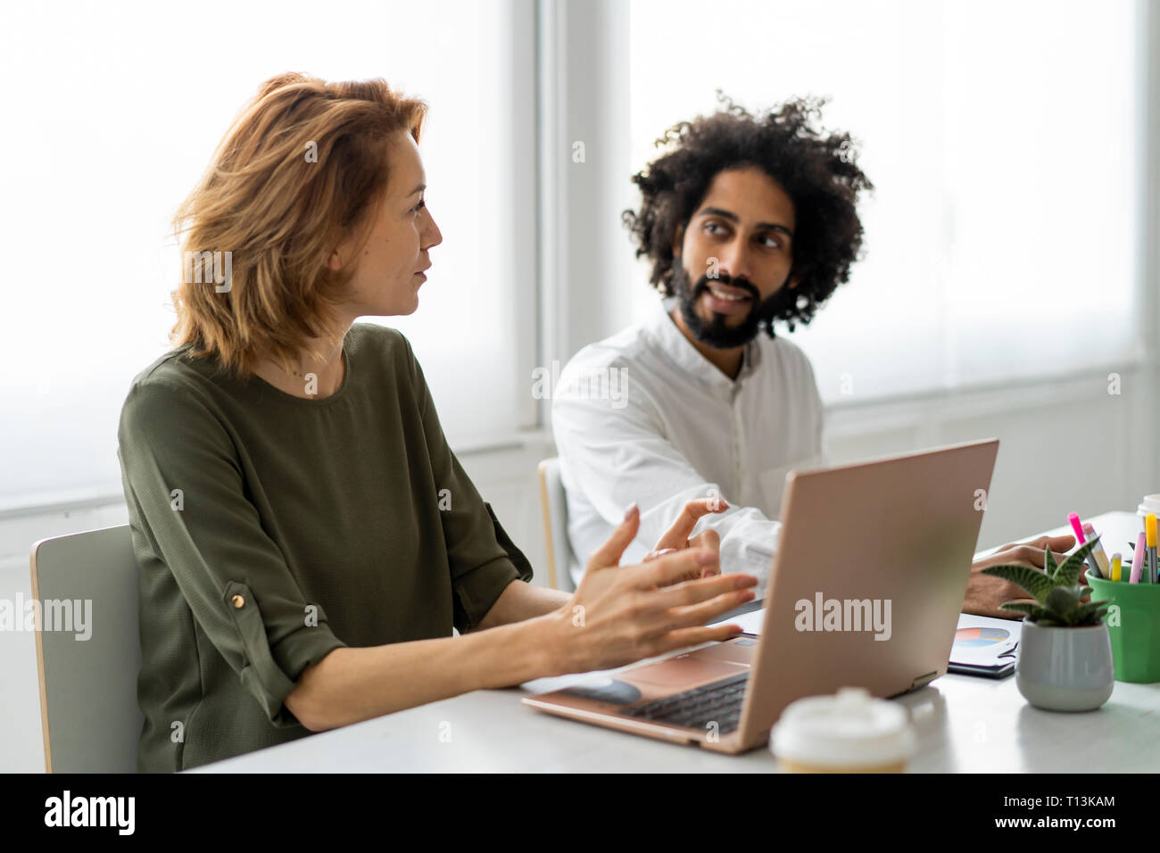 Young business people in coworking space supporting each other Stock Photo