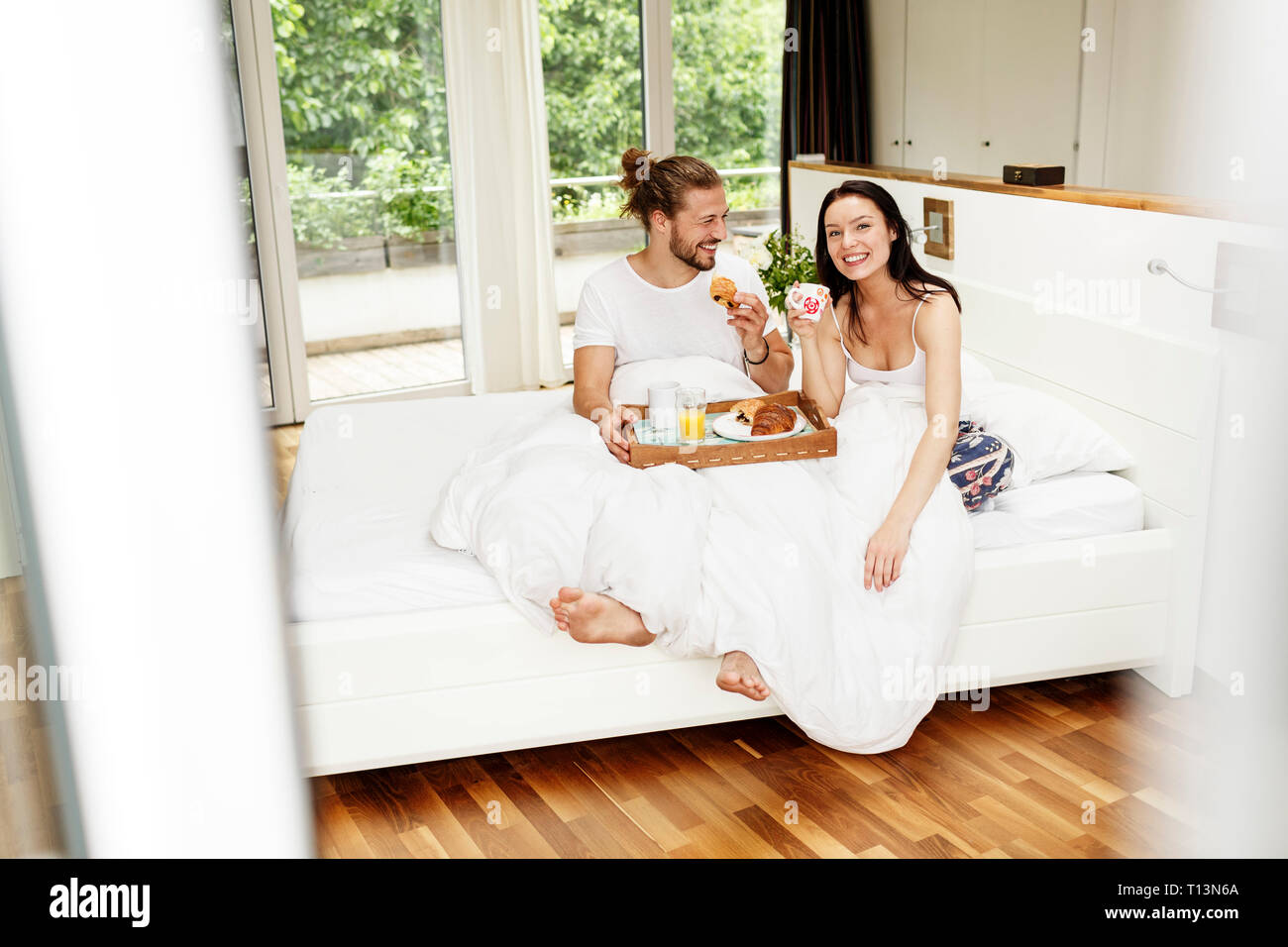 Affectionate couple having breakfast in bed Stock Photo