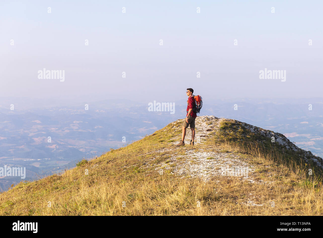 Italy, Monte Nerone, hiker on top of a mountain looking at panorama Stock Photo