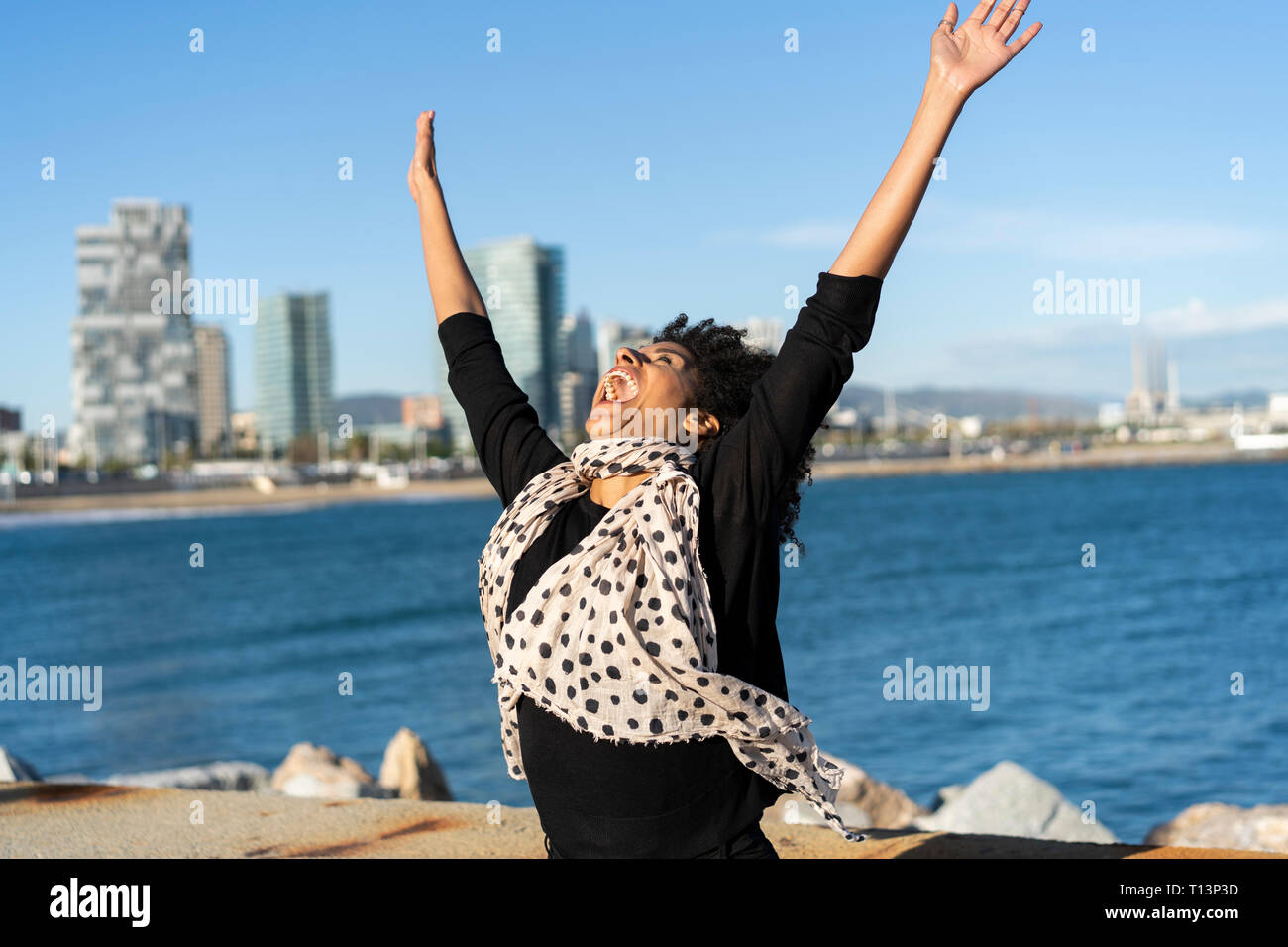 Spain, Barcelona, happy woman shouting of joy in front of the sea Stock Photo
