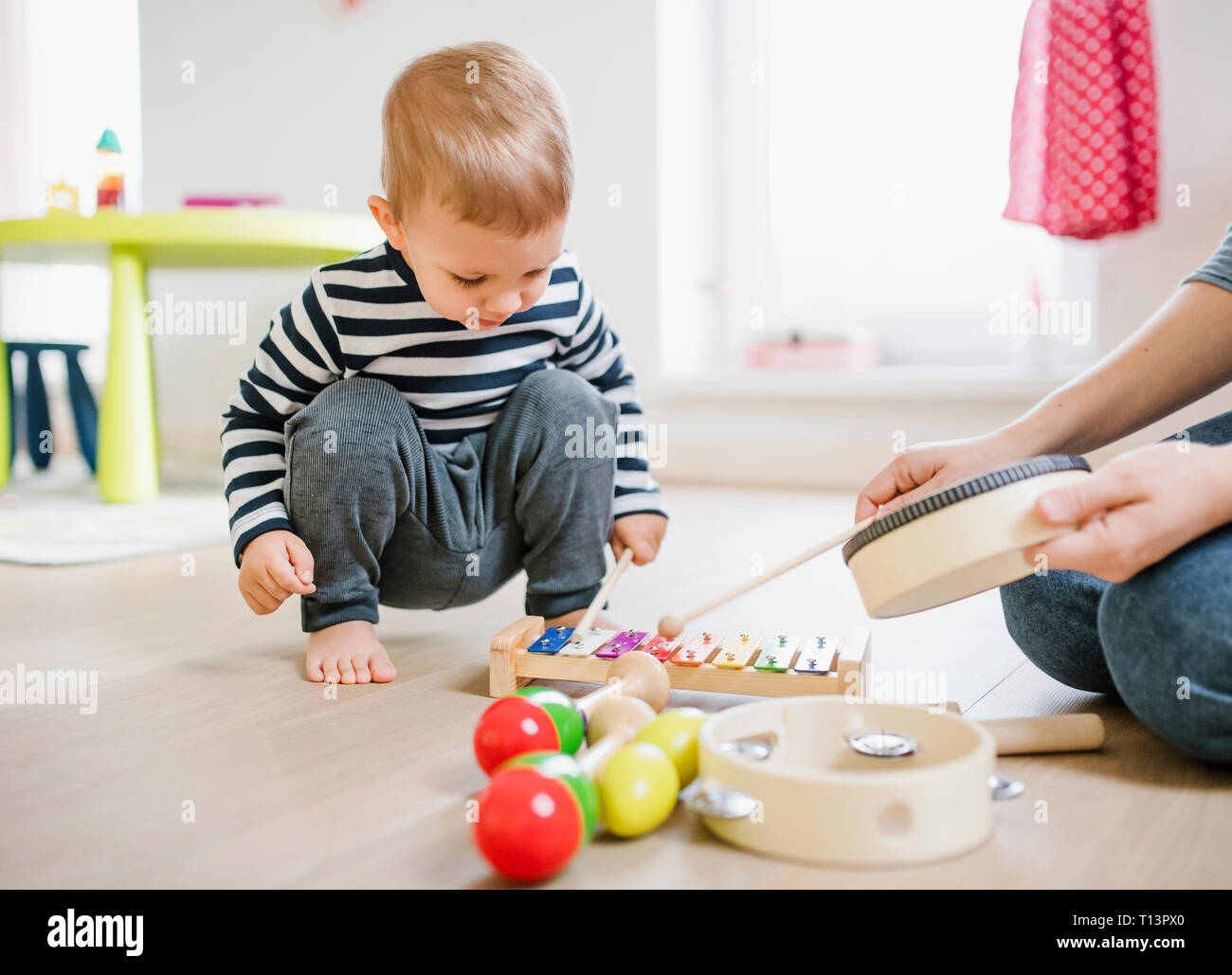 Mother and toddler son playing with musical instruments at home Stock ...