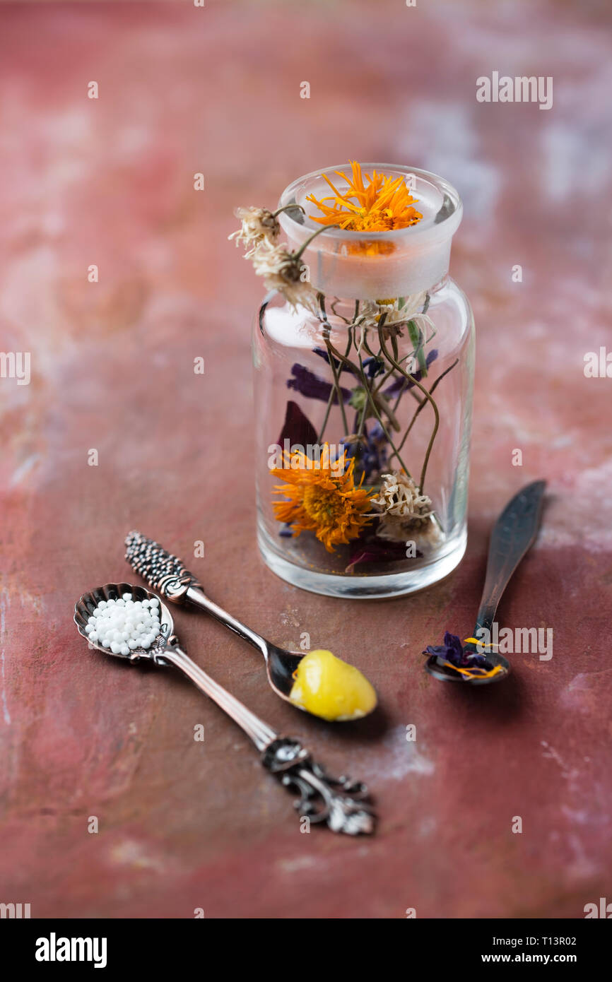 Blossoms of medical plants, medicine flask, marigold salve and globules Stock Photo