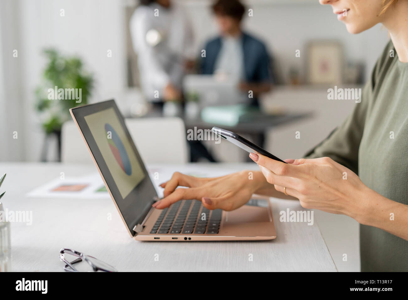 Young woman working in office, using laptop Stock Photo