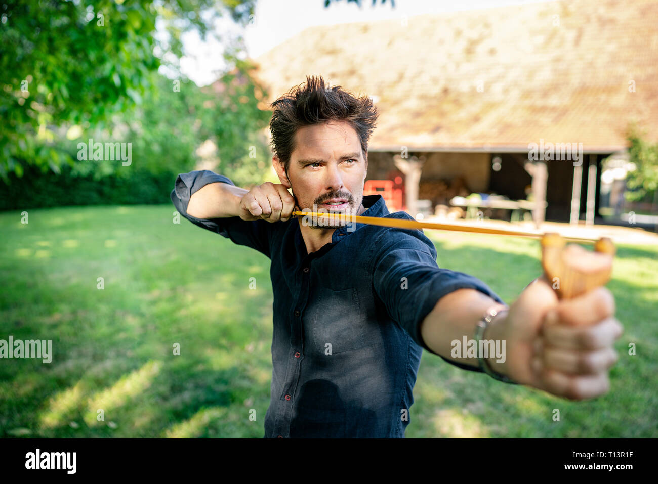 Man aimining with a slingshot Stock Photo