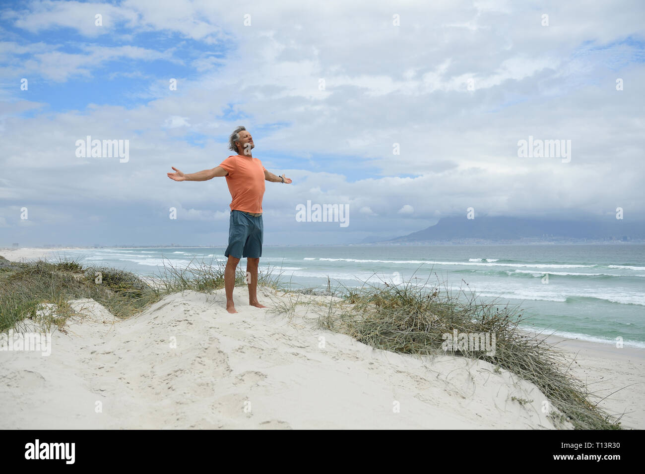 South Africa, man raising arms at Bloubergstrand Stock Photo
