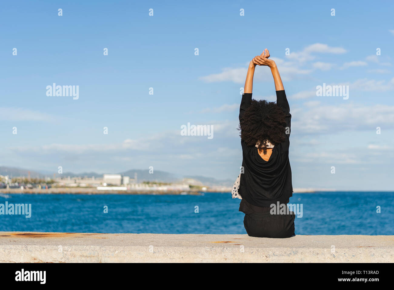 Back view woman sitting on wall hi-res stock photography and images - Alamy