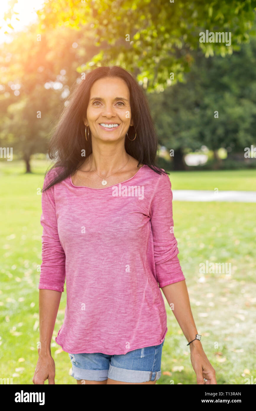 Portrait of relaxed mature woman in a park in summer Stock Photo - Alamy