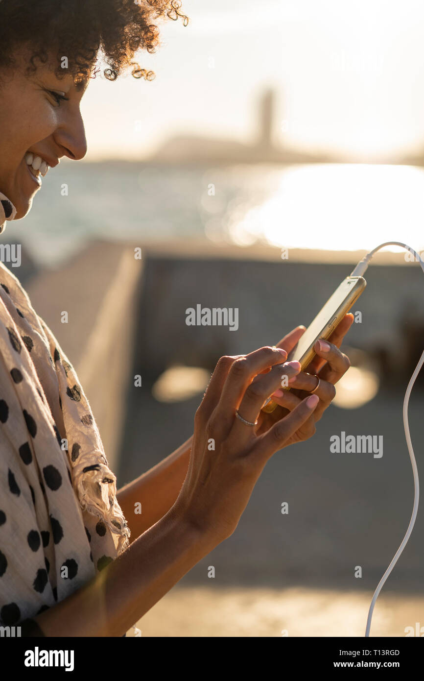 Smiling woman using smartphone Stock Photo